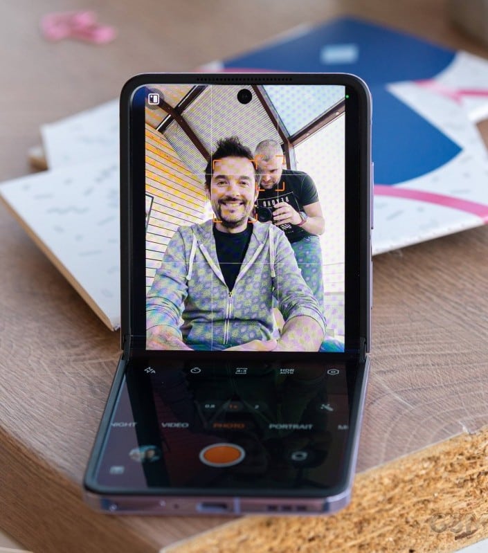 Due amici sorridenti si scattano un selfie con uno smartphone.