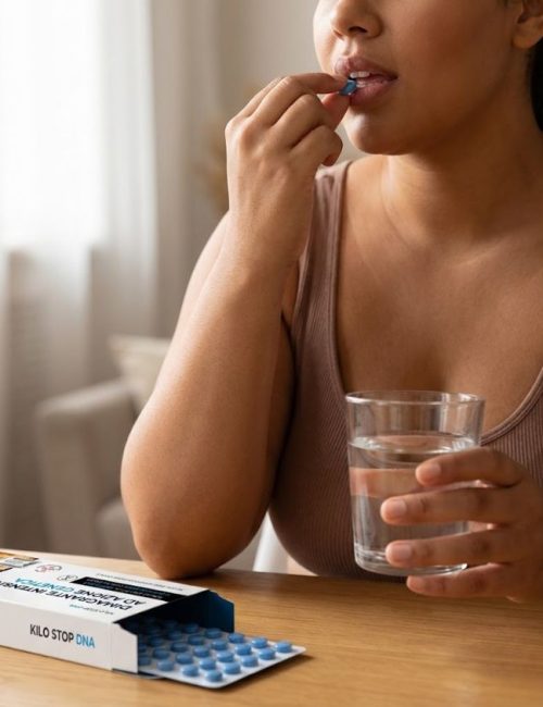 Donna che assume integratore Kilo Stop DNA con acqua a casa.